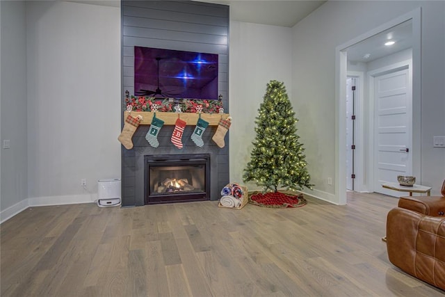 living room with hardwood / wood-style flooring and a tiled fireplace