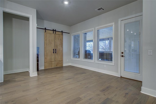 interior space featuring a barn door and hardwood / wood-style flooring