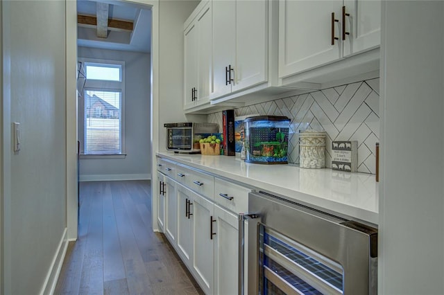 bar with white cabinetry, wood-type flooring, backsplash, and wine cooler