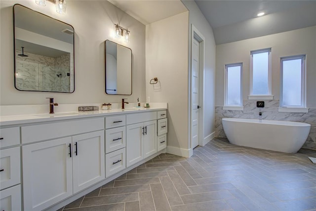 bathroom with plus walk in shower, tile patterned flooring, vanity, and tile walls