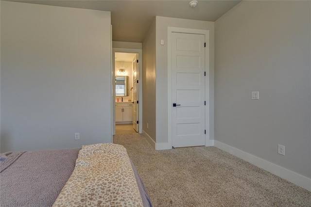 bedroom with light carpet and connected bathroom