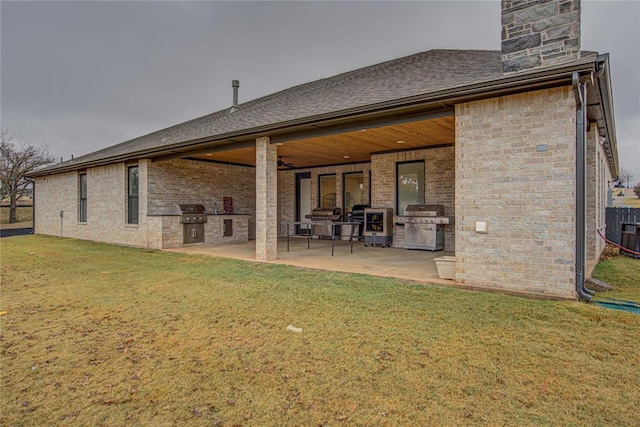 rear view of property with a lawn, area for grilling, and a patio