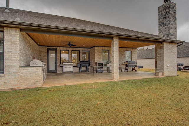 back of house featuring a yard, area for grilling, ceiling fan, and a patio area