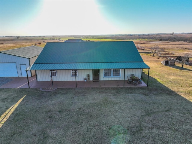 exterior space featuring a yard, a rural view, and a garage