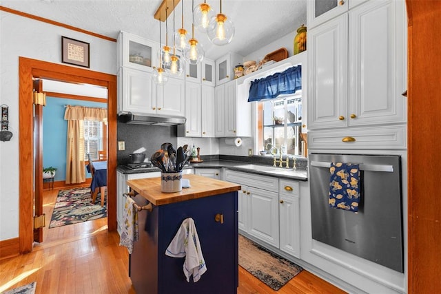 kitchen with sink, white cabinets, pendant lighting, and a kitchen island