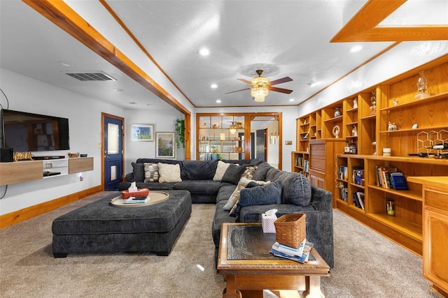 living room with carpet flooring, ceiling fan, and ornamental molding