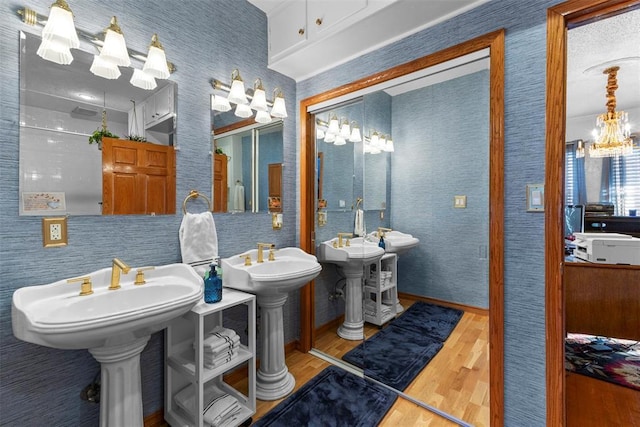 bathroom featuring a chandelier, hardwood / wood-style floors, and double sink