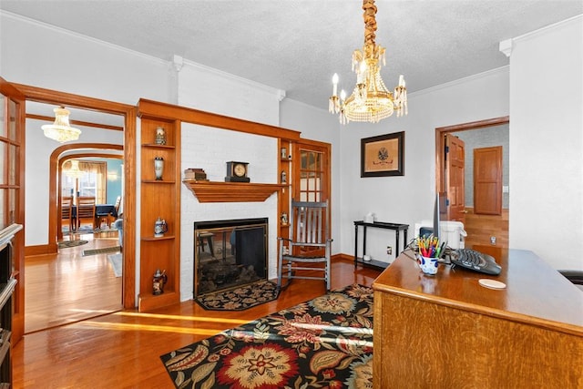 office area with hardwood / wood-style flooring, ornamental molding, a fireplace, and a textured ceiling