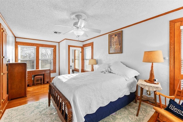 bedroom featuring a textured ceiling, light hardwood / wood-style flooring, ceiling fan, and ornamental molding