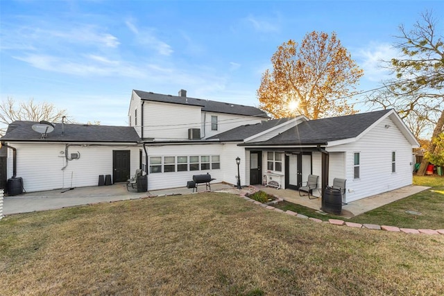 rear view of house with a lawn and a patio