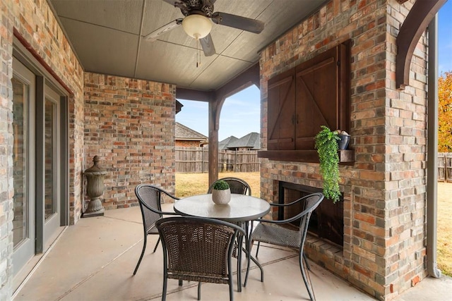 view of patio featuring an outdoor brick fireplace and ceiling fan