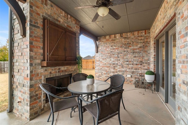 view of patio / terrace with an outdoor brick fireplace and ceiling fan