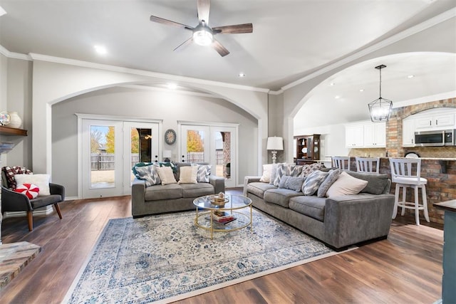 living room with dark hardwood / wood-style flooring, ceiling fan with notable chandelier, french doors, and ornamental molding