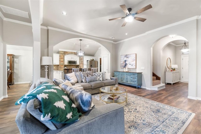 living room with ceiling fan, crown molding, and dark wood-type flooring