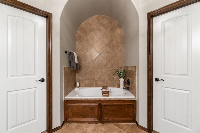 bathroom with tile patterned flooring and a relaxing tiled tub