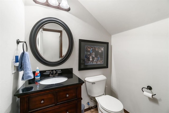 bathroom featuring vanity, vaulted ceiling, and toilet