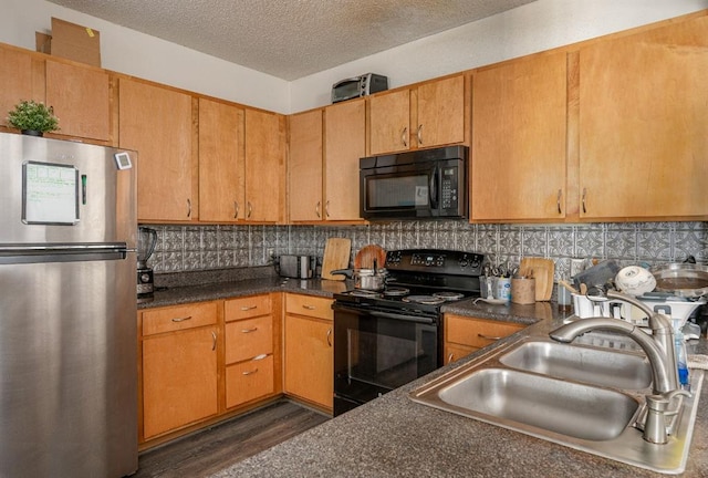 kitchen featuring sink, tasteful backsplash, dark hardwood / wood-style floors, a textured ceiling, and black appliances