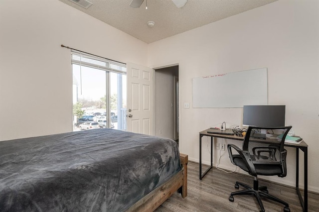 bedroom featuring ceiling fan, a textured ceiling, and hardwood / wood-style flooring