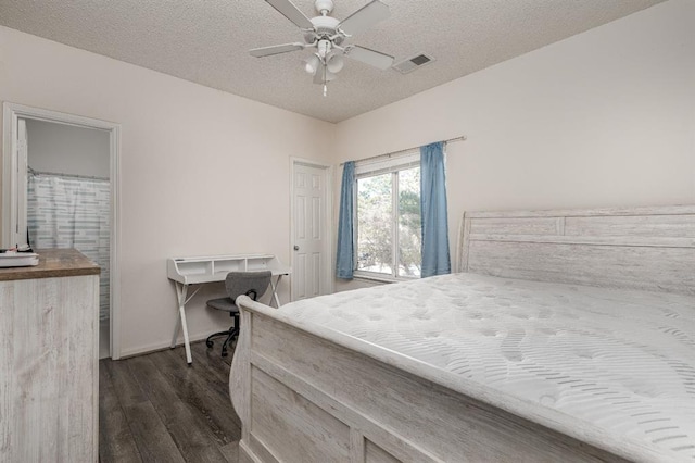 bedroom with ceiling fan, dark wood-type flooring, and a textured ceiling