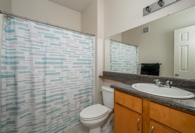 bathroom featuring tile patterned floors, vanity, a textured ceiling, and toilet