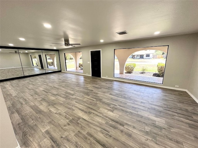 unfurnished living room with ceiling fan and wood-type flooring