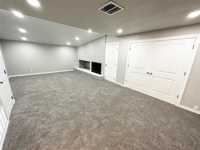 basement featuring a fireplace and dark colored carpet