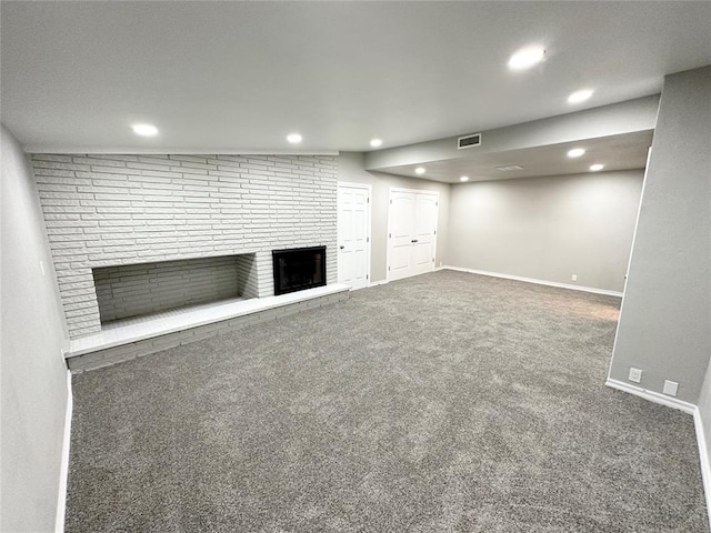 basement with dark carpet and a fireplace