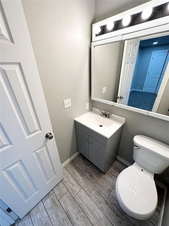 bathroom with vanity, wood-type flooring, and toilet