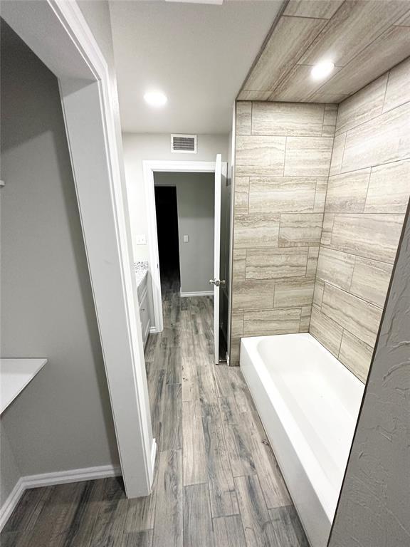 bathroom with vanity, wood-type flooring, and plus walk in shower