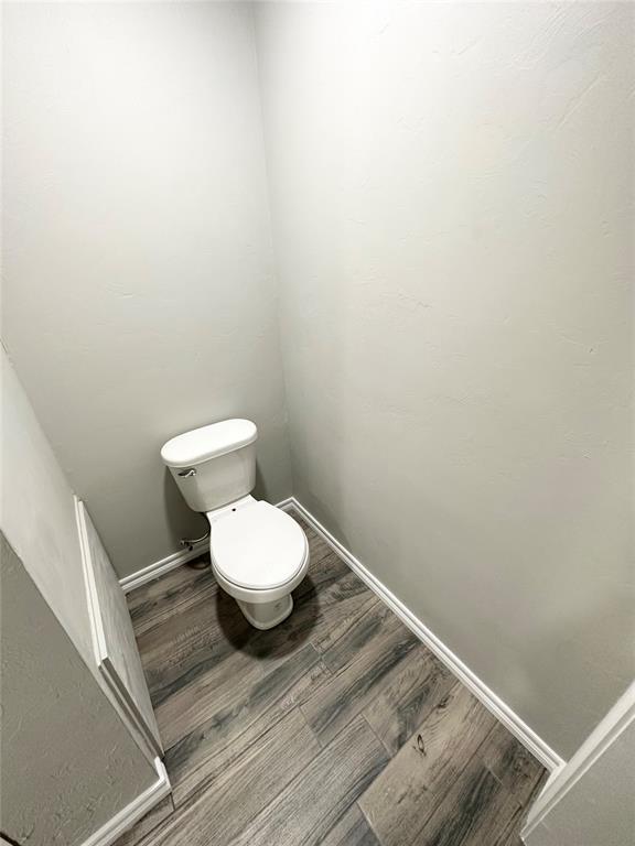 bathroom with hardwood / wood-style flooring and toilet