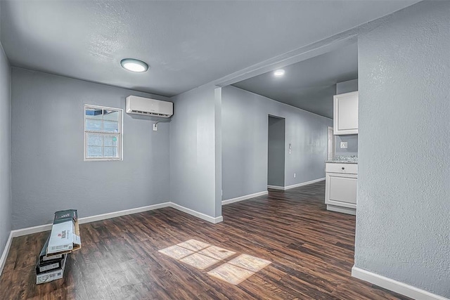 empty room with dark hardwood / wood-style flooring, an AC wall unit, and a textured ceiling