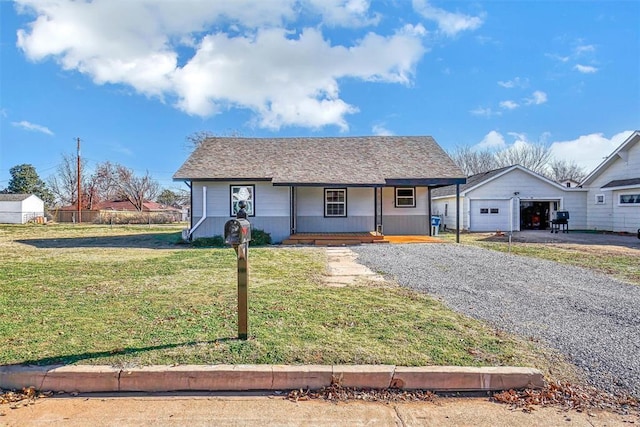 view of front of property with an outbuilding, a front lawn, covered porch, and a garage