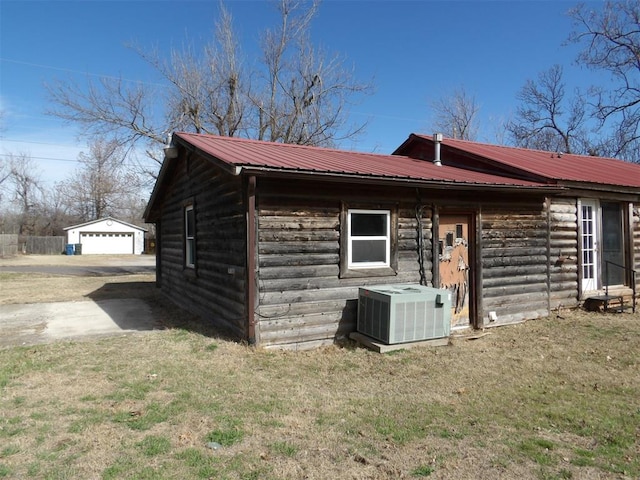 view of home's exterior with a yard, central AC, a garage, and an outdoor structure