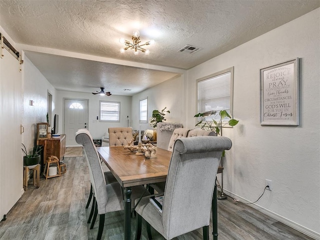 dining area featuring hardwood / wood-style floors, a textured ceiling, and ceiling fan