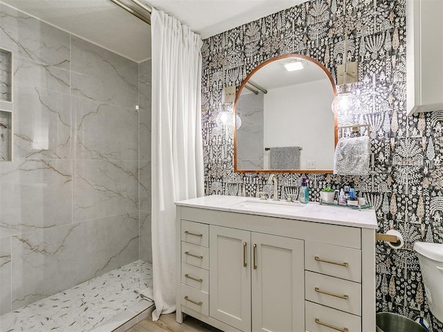 bathroom featuring backsplash, toilet, vanity, and tiled shower