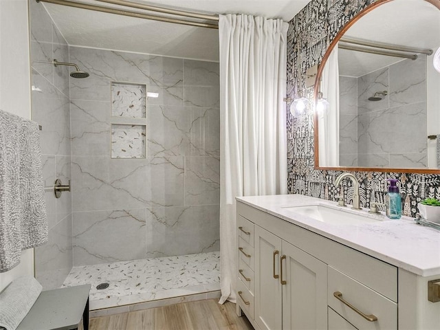 bathroom featuring hardwood / wood-style floors, vanity, curtained shower, and backsplash