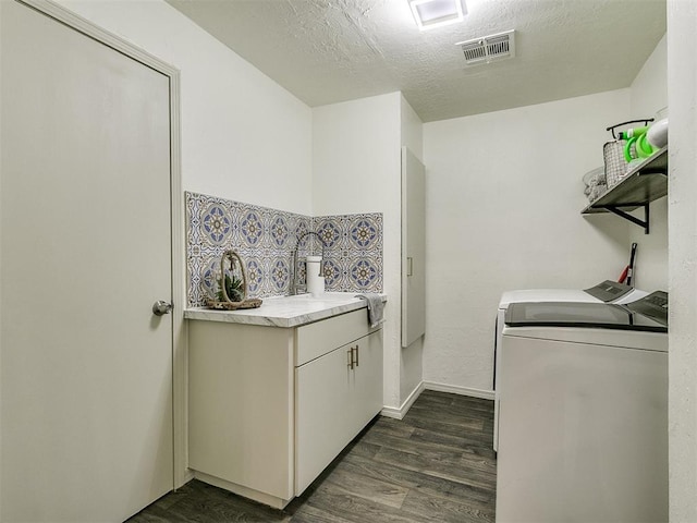 laundry room with washer and clothes dryer, dark hardwood / wood-style flooring, and a textured ceiling