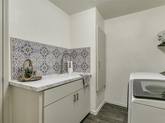 kitchen featuring washer / dryer, dark hardwood / wood-style flooring, and sink