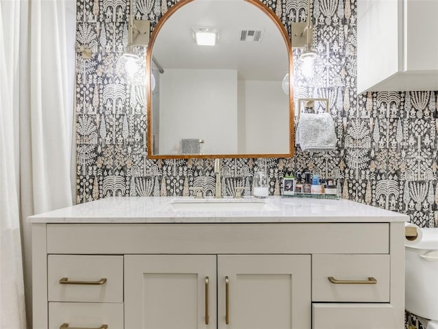 bathroom featuring toilet, visible vents, and vanity