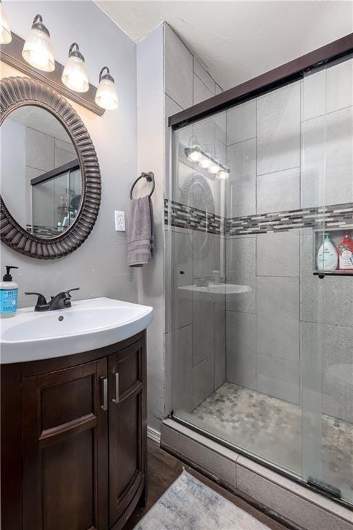 bathroom featuring hardwood / wood-style floors, an enclosed shower, and sink