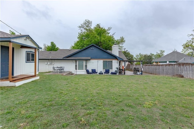 back of house with a patio area and a yard