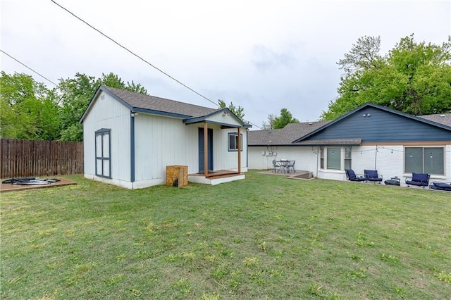 back of property with a yard and a patio area