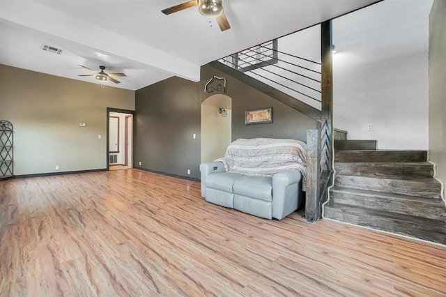 unfurnished living room featuring beamed ceiling, ceiling fan, and light hardwood / wood-style floors