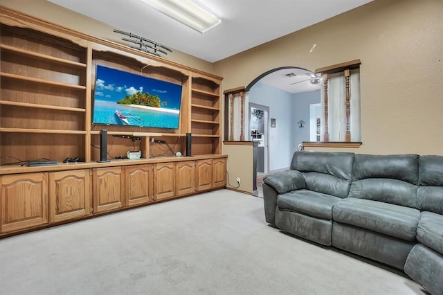 carpeted living room with ceiling fan