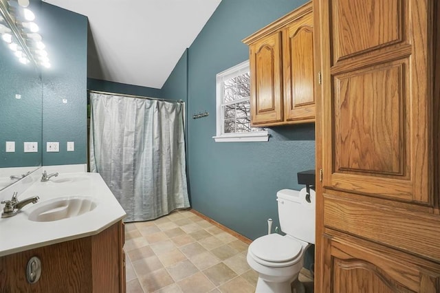 bathroom with vanity, toilet, and vaulted ceiling