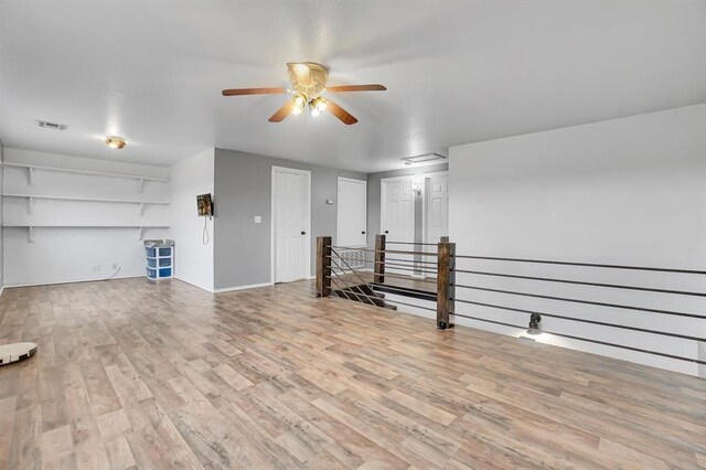 unfurnished living room featuring ceiling fan and light hardwood / wood-style flooring