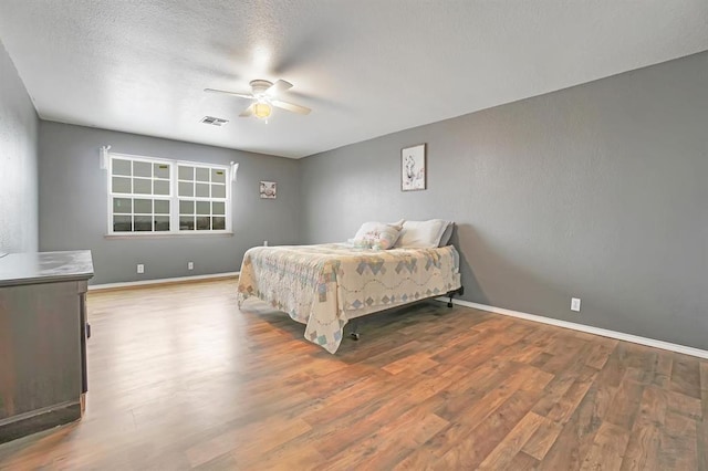 bedroom featuring ceiling fan, a textured ceiling, and light hardwood / wood-style flooring