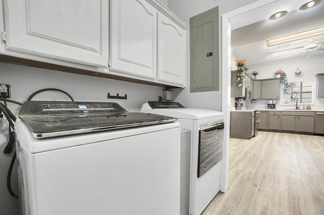 washroom with ceiling fan, cabinets, light hardwood / wood-style flooring, electric panel, and washer and dryer