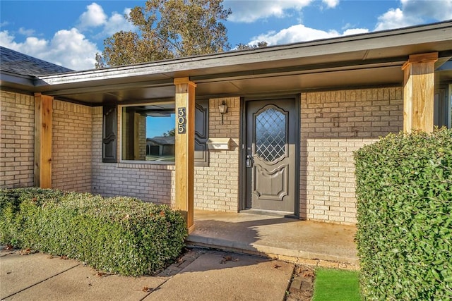 view of exterior entry featuring covered porch