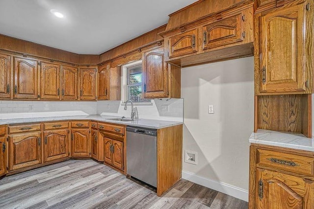 kitchen featuring dishwasher, light wood-type flooring, tasteful backsplash, and sink